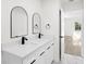 Bathroom with double sinks, quartz countertops, sleek black fixtures, and arch top mirrors at 3401 E Hanna Ave, Tampa, FL 33610