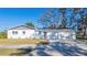 Single-story home with white paint, gray accents, a two-car garage, and a healthy front lawn at 3401 E Hanna Ave, Tampa, FL 33610