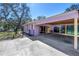 Single-story light purple home with a covered carport and a fenced yard with large trees at 5010 109Th N Way, St Petersburg, FL 33708
