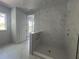 Bathroom showcasing marble shower and flooring, and white cabinets at 509 N Bradford Ave, Tampa, FL 33609