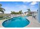 Private pool with inviting blue water, lush landscaping, and poolside seating in a fenced-in backyard at 6029 Bayway Ct, New Port Richey, FL 34652