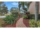 Backyard garden path with tropical landscaping, mulch, and a fence line offering views of the lake at 650 Saxony Blvd, St Petersburg, FL 33716