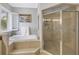 Inviting bathroom showcasing a tub with tile surround and a glass enclosed shower at 650 Saxony Blvd, St Petersburg, FL 33716