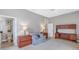 Comfortable bedroom featuring neutral walls, carpet floors, a love seat, and furniture for storage and relaxation at 650 Saxony Blvd, St Petersburg, FL 33716