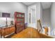 Hallway landing with hardwood floors and a vintage display cabinet at 650 Saxony Blvd, St Petersburg, FL 33716
