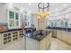 Kitchen featuring center island with granite countertop, stylish pendant lights, and cream-colored cabinets at 650 Saxony Blvd, St Petersburg, FL 33716