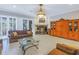 Bright living room with plantation shutters, fireplace, and elegant wood display cabinet at 650 Saxony Blvd, St Petersburg, FL 33716