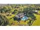 Beautiful aerial view of home with pool and outdoor seating area amidst lush greenery and fencing at 7213 Jones Rd, Odessa, FL 33556