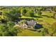 Aerial view of a home set on a sprawling lawn, accented by mature trees and a perimeter fence at 7213 Jones Rd, Odessa, FL 33556