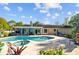 View of the backyard showcasing the in-ground pool, covered patio, and well-maintained landscaping at 7213 Jones Rd, Odessa, FL 33556
