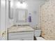 Bright bathroom featuring granite countertop vanity, decorative mirror, and a floral shower curtain at 7213 Jones Rd, Odessa, FL 33556