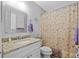 Bathroom with granite countertop vanity, decorative mirror and a floral shower curtain at 7213 Jones Rd, Odessa, FL 33556