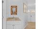 Bathroom with granite counters, framed mirror, white cabinets and entry door at 7213 Jones Rd, Odessa, FL 33556