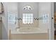 Large soaking tub features decorative tiling and a window with a whimsical design at 7213 Jones Rd, Odessa, FL 33556