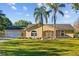 Charming single-story home featuring a well-manicured lawn, palm trees, and an attached two-car garage at 7213 Jones Rd, Odessa, FL 33556