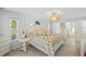 Bright main bedroom featuring windows, a floral-patterned bed, and a view of the ensuite bath at 7213 Jones Rd, Odessa, FL 33556