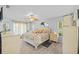 Spacious main bedroom with windows, a ceiling fan, and a comfortable bed with floral patterns at 7213 Jones Rd, Odessa, FL 33556