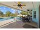 Covered patio features ceiling fans, tile flooring, and outdoor seating overlooking the sparkling pool and landscaped backyard at 7213 Jones Rd, Odessa, FL 33556