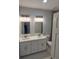Modern bathroom featuring double sinks, granite countertop, and contemporary lighting at 13224 Foresman Blvd, Port Charlotte, FL 33981