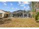 Exterior view of the home's screened-in pool with chairs and dining table, enhancing outdoor enjoyment at 18861 Maisons Dr, Lutz, FL 33558