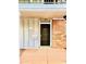 Close-up of a condo entrance featuring a black door, brick siding, and a mailbox under a sheltered roof at 200 Country Club Dr # 407, Largo, FL 33771