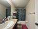 Cozy bathroom featuring dark vanity, a large mirror, and a shower with a patterned curtain at 20314 Starfinder Way, Tampa, FL 33647