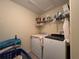 Functional laundry room with washer, dryer, shelving and storage at 20314 Starfinder Way, Tampa, FL 33647