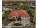 Aerial view of home with red tile roof, a circular driveway, and scenic pond at 3830 Moreno Dr, Palm Harbor, FL 34685