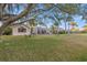 Spacious backyard offering serene lake views and mature shade trees at 3830 Moreno Dr, Palm Harbor, FL 34685