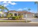 Beautiful home featuring a tile roof, well-manicured landscaping, and a spacious three-car garage at 3830 Moreno Dr, Palm Harbor, FL 34685