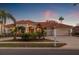 Elegant single-story home with a red tile roof, a circular driveway, and lush tropical landscaping at 3830 Moreno Dr, Palm Harbor, FL 34685