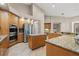 Gourmet kitchen featuring custom cabinets, granite countertops, stainless steel appliances, and a functional island at 3830 Moreno Dr, Palm Harbor, FL 34685