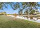 Beautiful lake view featuring mature trees and well-maintained landscaping at 3830 Moreno Dr, Palm Harbor, FL 34685
