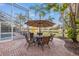 Charming brick patio with an umbrella-covered table and chairs, offering stunning views of the lake at 3830 Moreno Dr, Palm Harbor, FL 34685