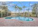 Enjoy this screened in pool with lake view and brick paver patio at 3830 Moreno Dr, Palm Harbor, FL 34685