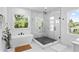 Modern bathroom with a sleek glass-enclosed shower and a soaking tub, enhanced by natural light at 4406 W Euclid Ave, Tampa, FL 33629