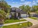 Contemporary home exterior with a balcony, garage, green lawn and landscaped yard at 4406 W Euclid Ave, Tampa, FL 33629