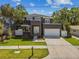 Well-maintained home with a contemporary design, featuring a balcony, attached garage, and green lawn at 4406 W Euclid Ave, Tampa, FL 33629