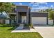 Contemporary two-story home with a gray exterior, a rooftop deck, and an attached one car garage at 4406 W Euclid Ave, Tampa, FL 33629