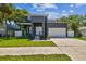 Modern two-story home with a well-manicured lawn, a two-car garage, and a rooftop patio at 4406 W Euclid Ave, Tampa, FL 33629