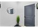 Hallway with gray door and neutral walls. A mirror hangs above a decorative grass at 4406 W Euclid Ave, Tampa, FL 33629