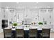 Modern white kitchen with chevron backsplash, stainless appliances, a large island and pendant lighting at 4406 W Euclid Ave, Tampa, FL 33629