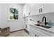 Laundry room includes white cabinets, matte black hardware, and a sink with countertop at 4406 W Euclid Ave, Tampa, FL 33629