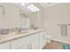 Well-lit bathroom with double sinks, tile floors, a toilet, and a large framed mirror at 7718 Landcare Ln, Tampa, FL 33616