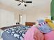 Cozy bedroom featuring ceiling fan, built-in desk, and walk-in closets at 7718 Landcare Ln, Tampa, FL 33616