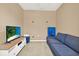 Cozy bonus room featuring a comfortable blue sofa and entertainment setup, perfect for relaxation and leisure at 7718 Landcare Ln, Tampa, FL 33616