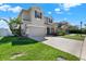 Side view of a charming two-story home with a well-manicured lawn and two-car garage at 7718 Landcare Ln, Tampa, FL 33616