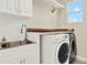 Well-equipped laundry room with modern washer and dryer, sink, and ample counter space for convenience at 7718 Landcare Ln, Tampa, FL 33616