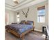 Bright primary bedroom with trey ceilings, windows, and wood-look flooring at 7718 Landcare Ln, Tampa, FL 33616