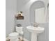 Well-lit powder room with a modern pedestal sink and decorative wall decor at 7718 Landcare Ln, Tampa, FL 33616
